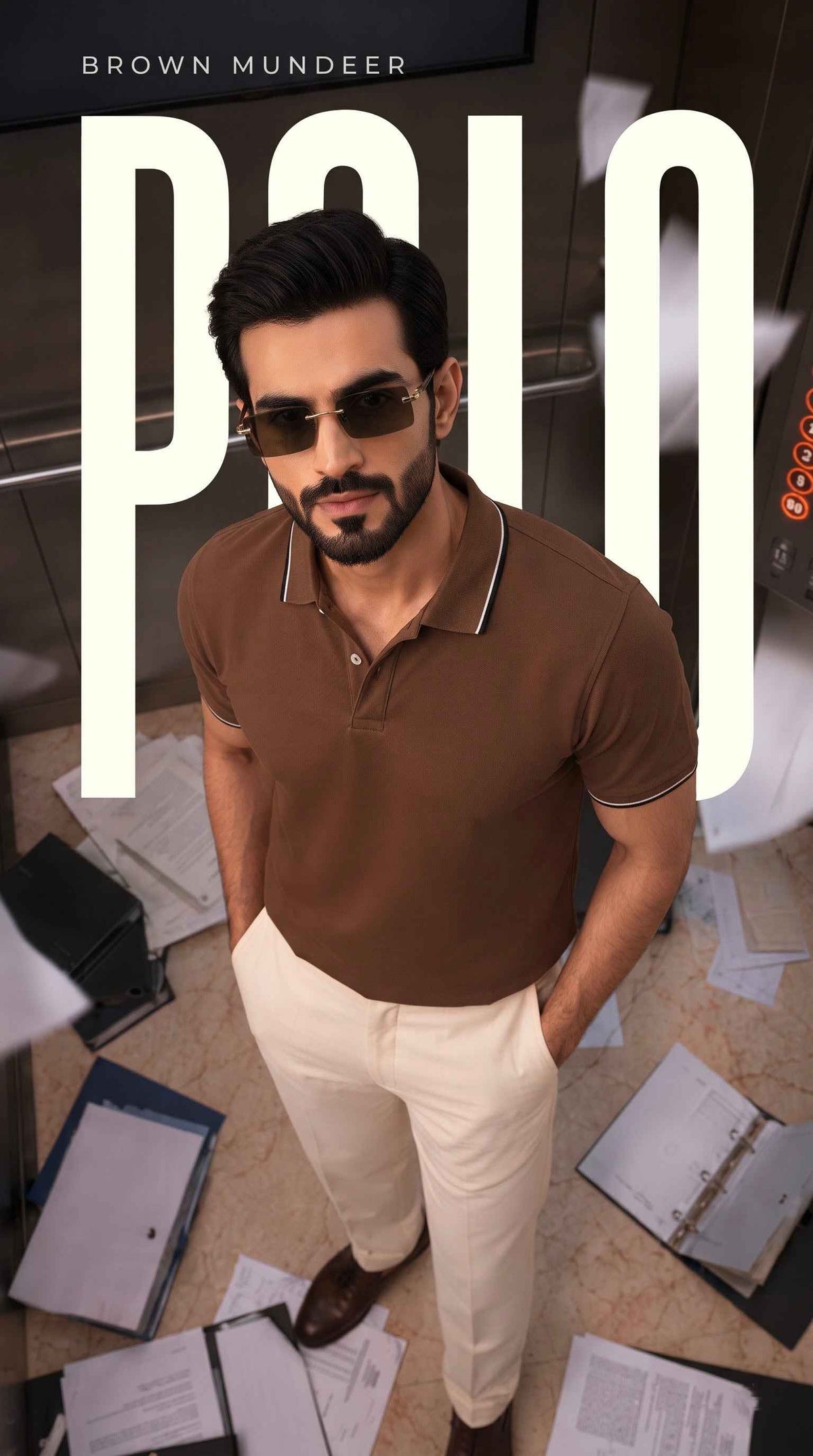 Man in brown polo shirt and cream trousers wearing sunglasses standing amidst scattered papers.